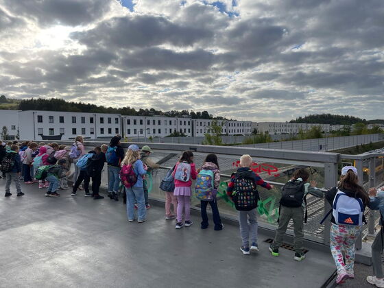 Schüler blicken von einer Brücke hinab auf Bahngleise