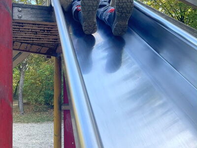 Ein Junge mit einer Plüschente auf einer Rutsche