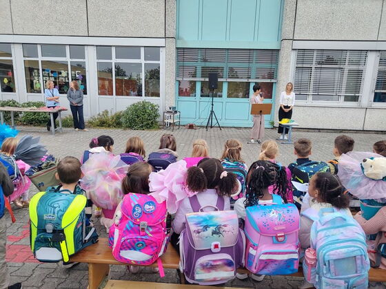 Erstklässler mit Schulranzen und Schultüten im Schulhof