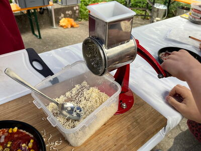 Käse wird mit einer Käsereibe gerieben